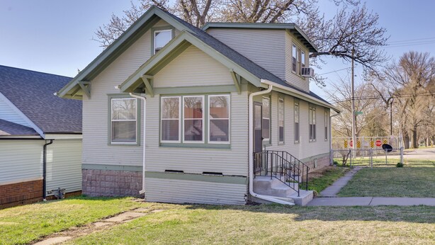 A single-story house with a front porch, a small staircase, and a garage. - Quaint Omaha Home < 5 Mi to Downtown! (Omaha)