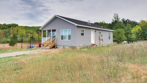 A single-story house with a front porch, a small deck, and a visible garage door. - Family Home in Rapid City ~ 4 Mi to Torch Lake! (Rapid City)