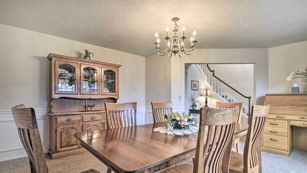 A dining room with a wooden table and chairs, a chandelier, and a wooden cabinet. - Portland Area Home, 32 Mi to Mt Hood! (Boring)