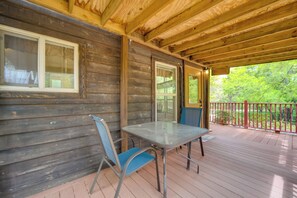 Eine Holzhütte mit Veranda, Tisch und zwei Stühlen.