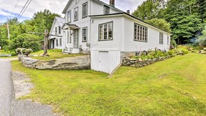 A two-story white house with a stone foundation, a front porch, and a chimney. - Rustic Roxbury Ski Farmhouse With Trails! (Roxbury)
