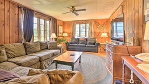 A cozy living room with a sectional sofa, a coffee table, and a television. - Rustic Roxbury Ski Farmhouse With Trails! (Roxbury)