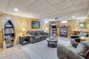 Un salon chaleureux avec une cheminée, une bibliothèque et un coin salon confortable.