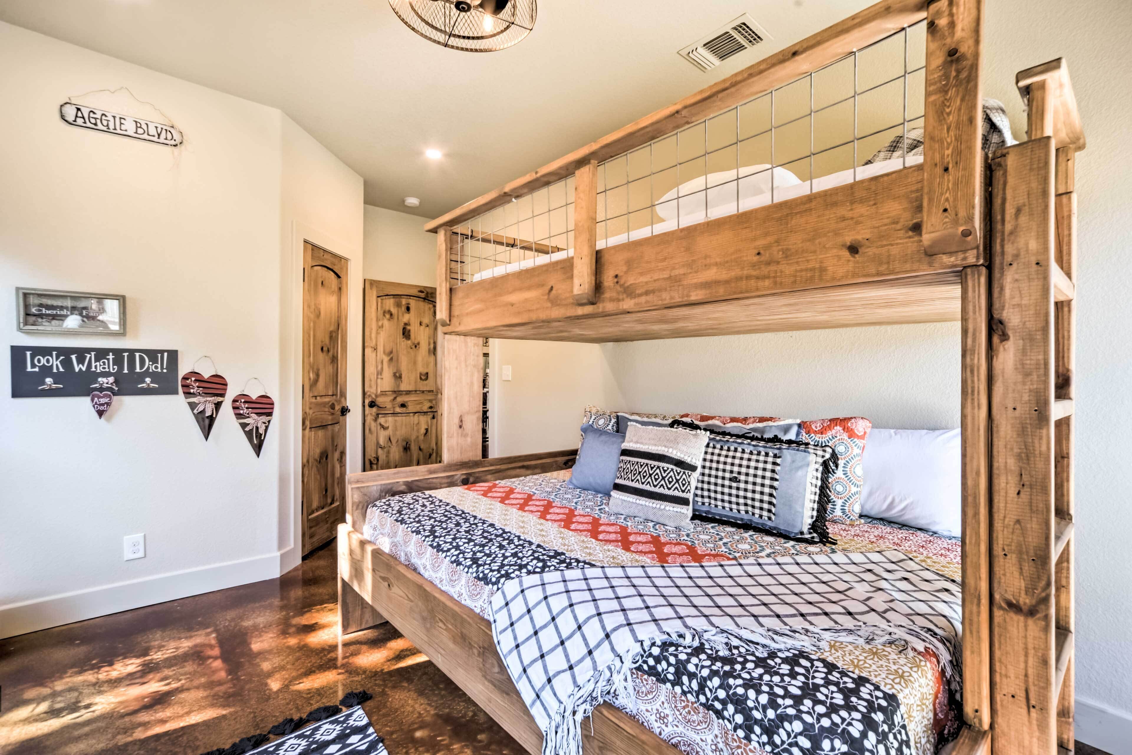 A bunk bed with a wooden headboard, a patterned bedspread, and multiple pillows.