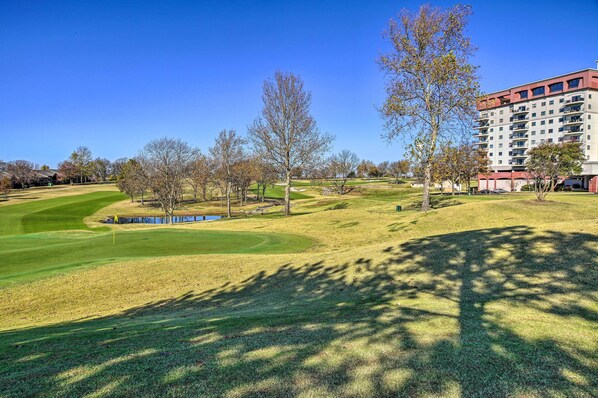 A golf course with a building in the background. - Balcony & Lake View: Modern Condo in Monkey Island (Afton)