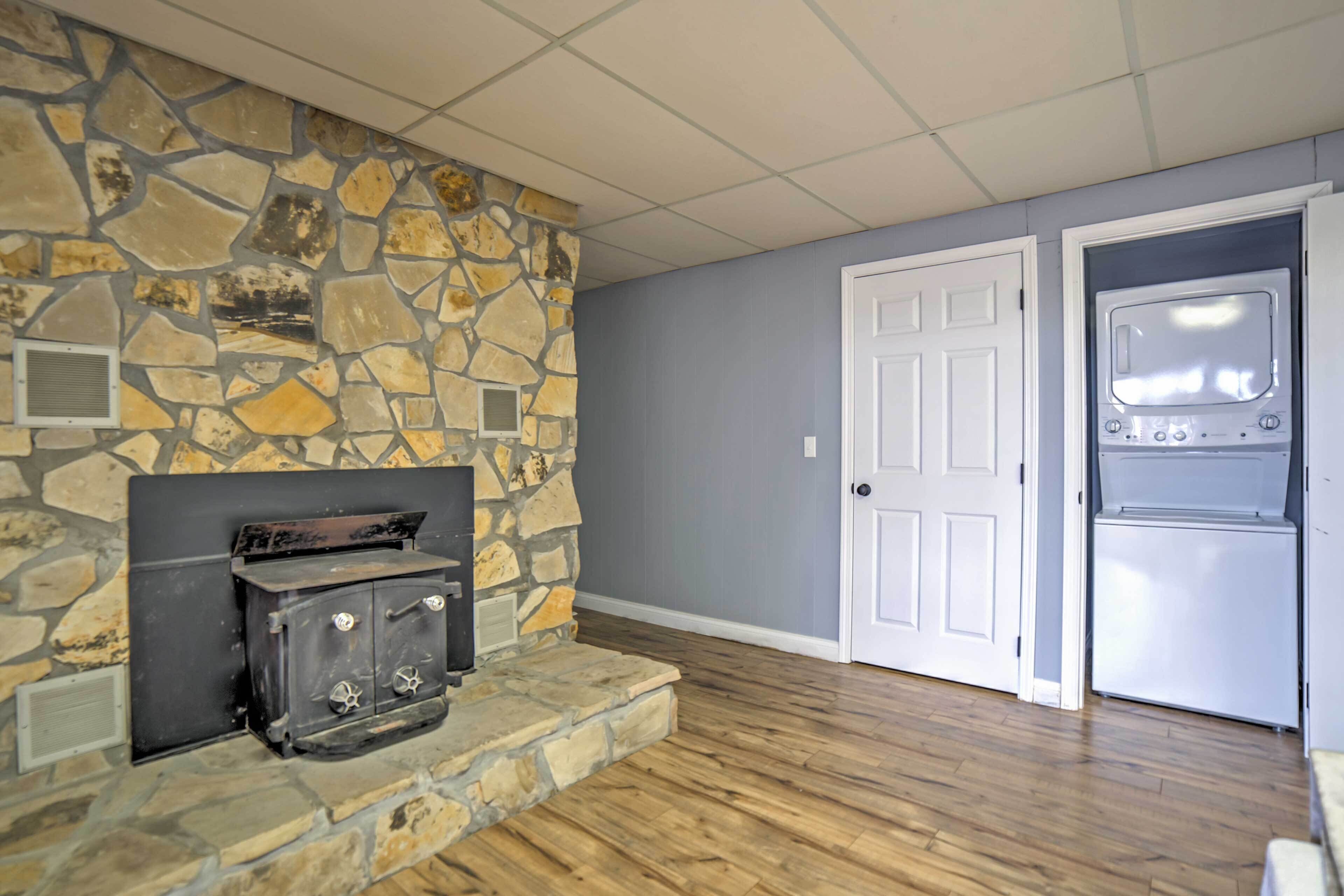A room with a stone fireplace, a white door, and a built-in oven.