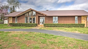 A modern two-story house with a sloped roof, large windows, and a stone foundation. - Monticello Home w/ Multi-level Deck on 2 Acres! (Monticello)
