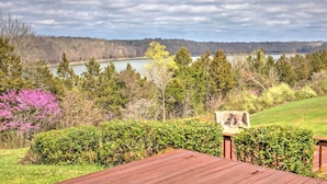 A view of a lake surrounded by trees and a wooden deck. - Monticello Home w/ Multi-level Deck on 2 Acres! (Monticello)
