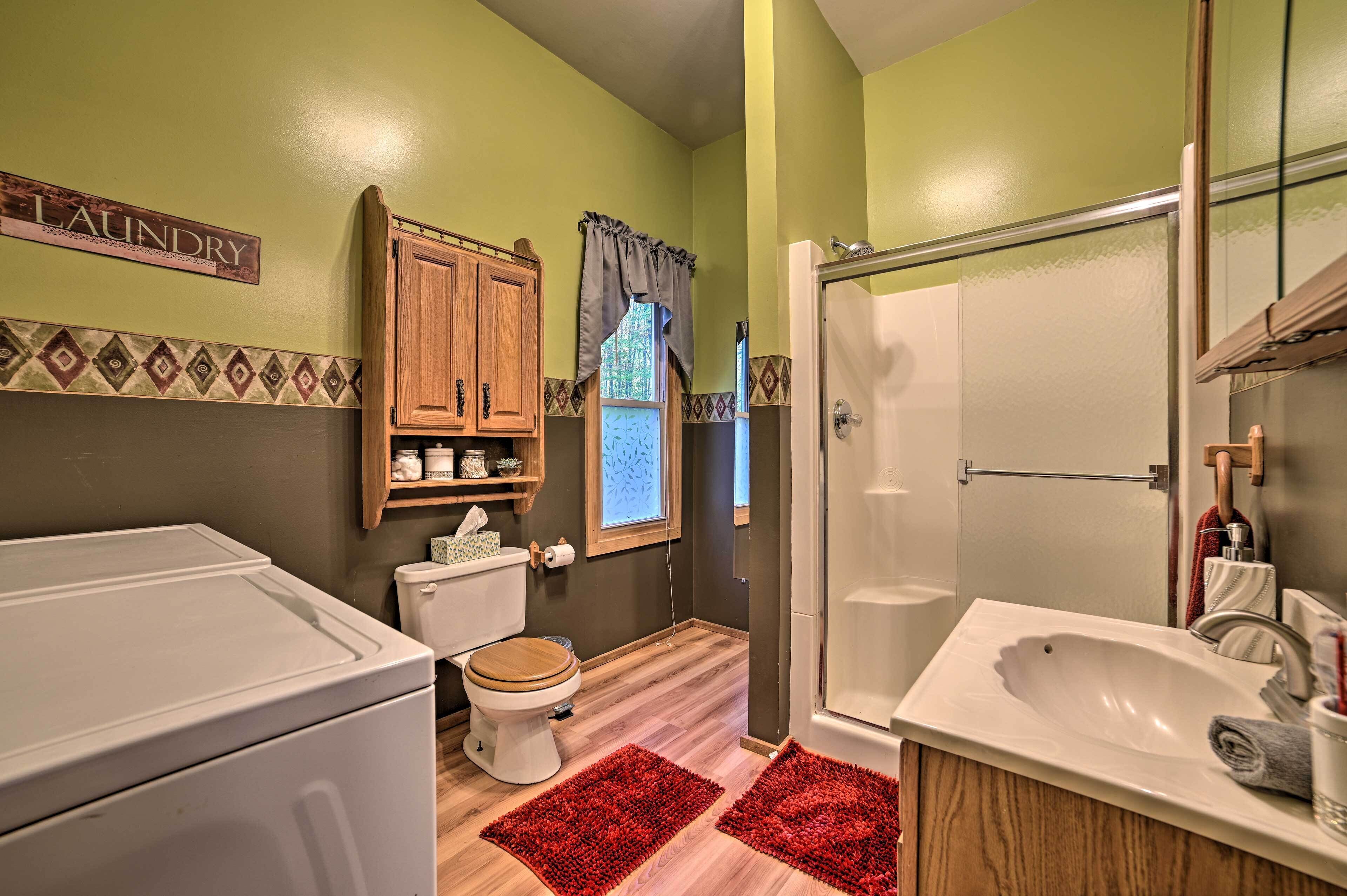 A compact bathroom with a toilet, a shower, and a sink.