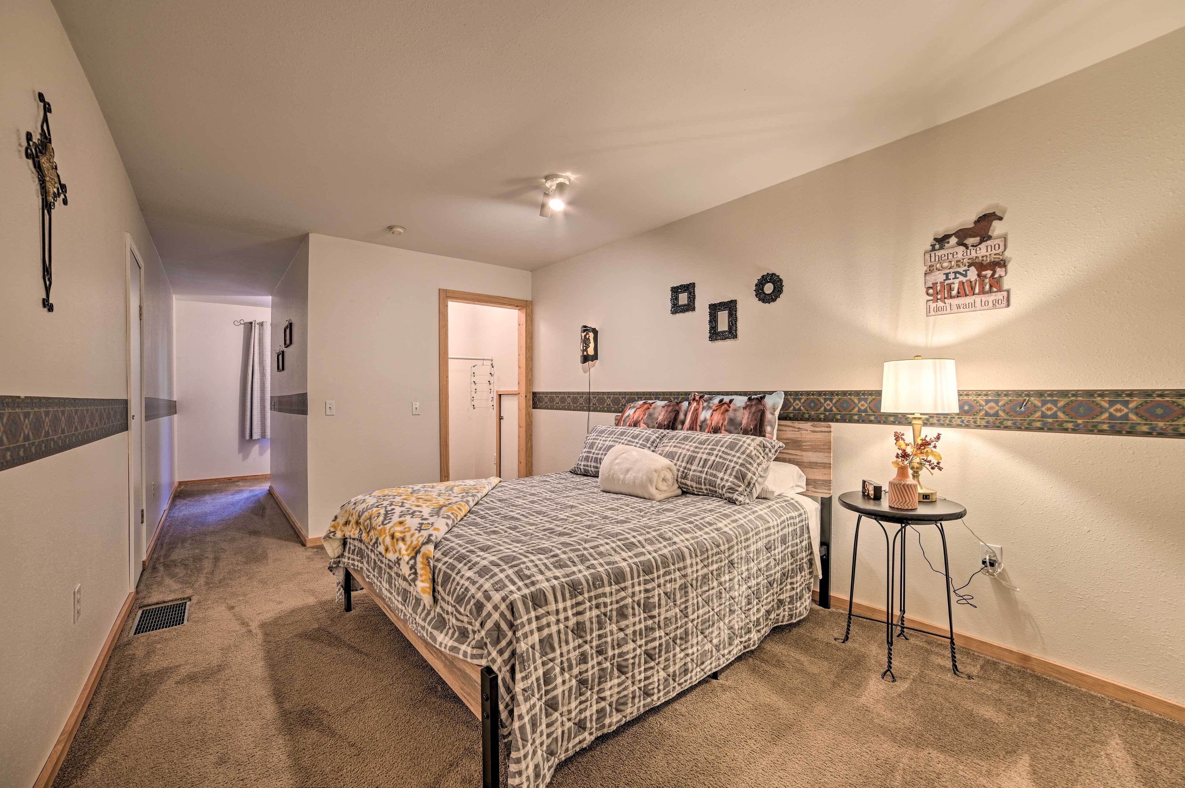 Une chambre à coucher avec un lit, une table de chevet avec une lampe et un mur décoré de différents objets.