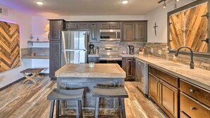 A modern kitchen with a central island, stainless steel appliances, and a herringbone-patterned backsplash. - 4 Mi to Dtwn: Rustic Fort Worth Apt (Fort Worth)