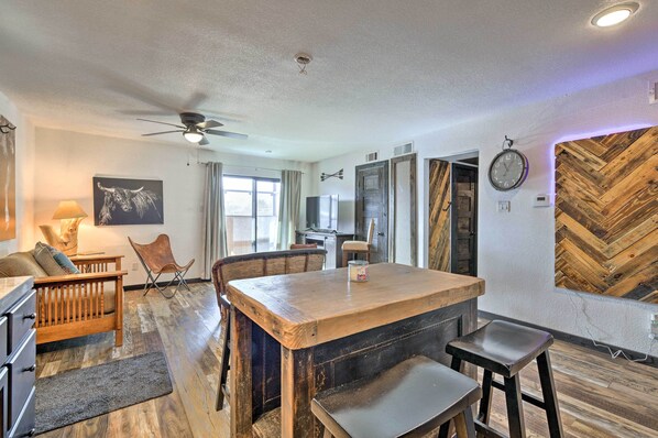 A dining area with a wooden table and chairs, a ceiling fan, and a herringbone wood wall. - 4 Mi to Dtwn: Rustic Fort Worth Apt (Fort Worth)
