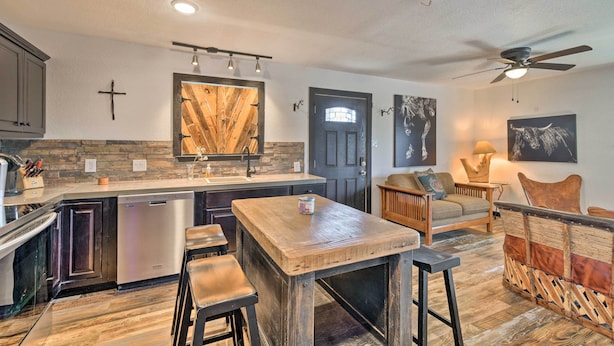 A modern kitchen with a central island, built-in appliances, and a dining area with a wooden table and bar stools. - 4 Mi to Dtwn: Rustic Fort Worth Apt (Fort Worth)