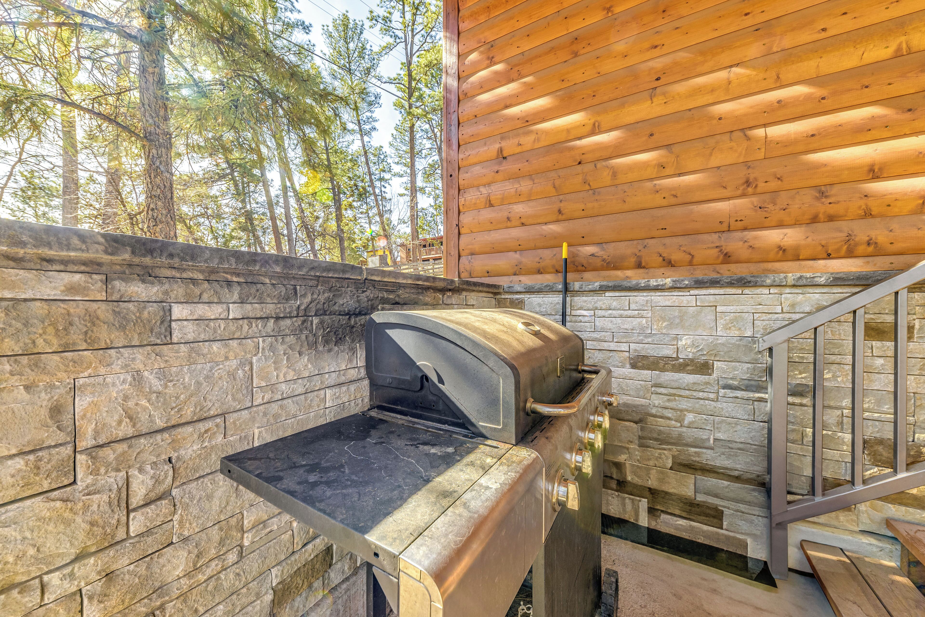 A stone wall with a built-in grill and a wooden deck.