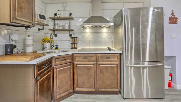 A modern kitchen with wooden cabinets, a stainless steel refrigerator, and a built-in oven. - Saddle Brook Studio With Patio - Near Nyc! (Saddle Brook)