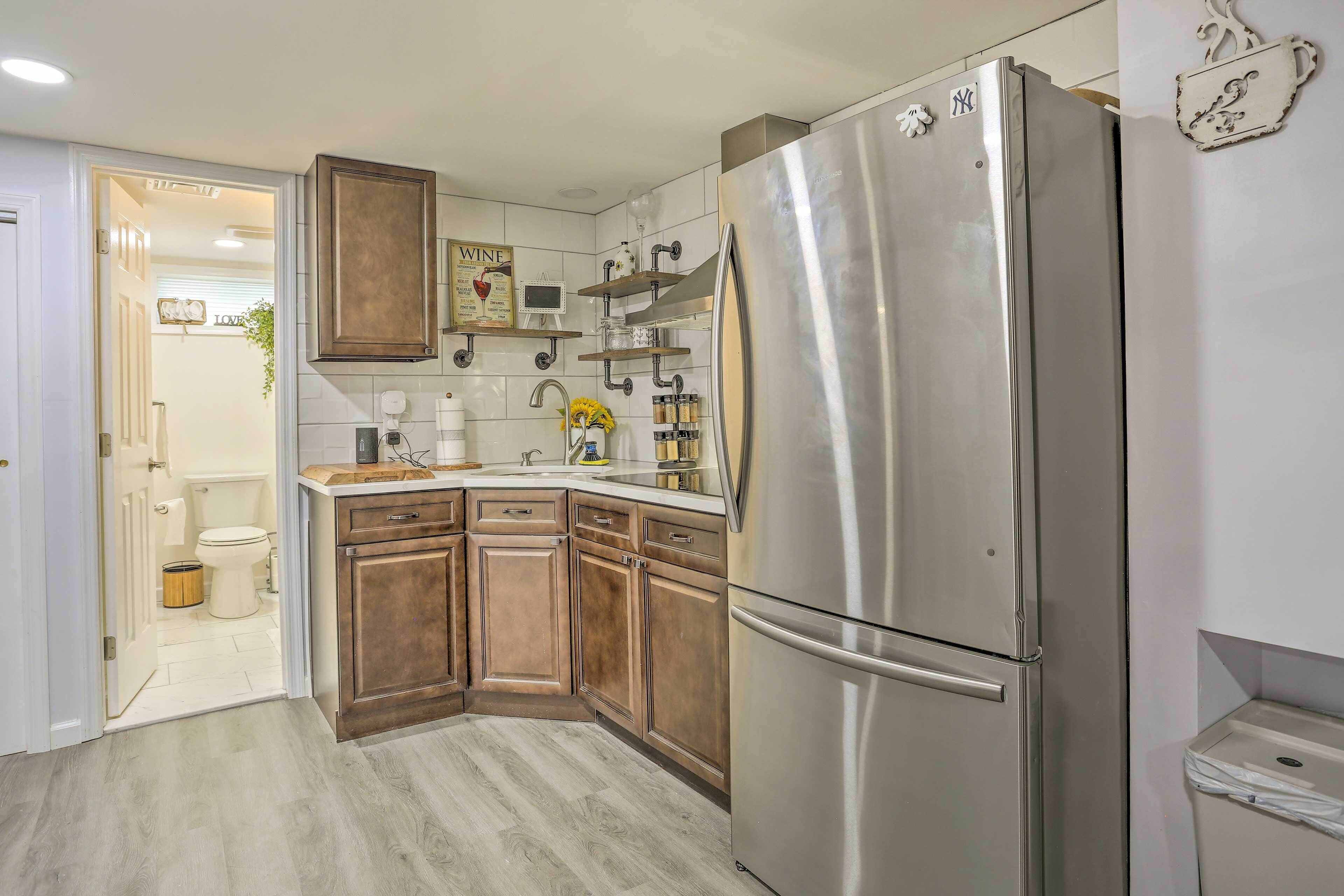 A modern kitchen with wooden cabinets, a stainless steel refrigerator, and a built-in oven.