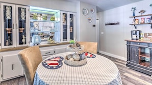 A dining area with a round table, chairs, and a buffet cabinet.