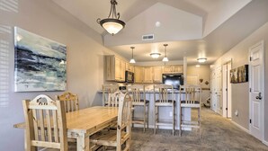 Una cocina amplia con armarios de madera, una isla central e iluminación colgante.