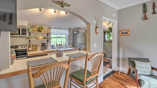 Una cocina con sillas de madera, una mesa de comedor y un refrigerador.