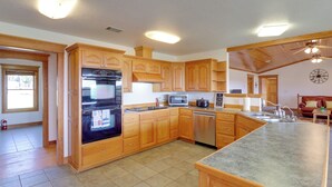 Una cocina amplia con gabinetes de madera, un refrigerador de acero inoxidable, un microondas y un lavavajillas.