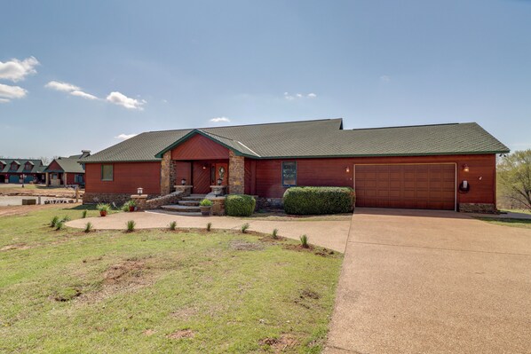 A two-story house with a red brick exterior, a stone foundation, and a green roof. - Mountain Views + Shared Pool: Ozarks Family Home (Shirley)