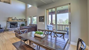 A spacious living area with a fireplace, a dining table, and a view of the outdoors. - Spacious Resort Cabin in Manti-la Sal Mtns! (Fairview)