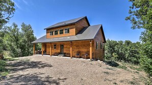 A two-story log cabin with a covered porch and a gravel driveway. - Spacious Resort Cabin in Manti-la Sal Mtns! (Fairview)