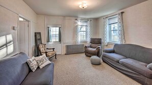 A living room with a sofa, armchair, and ottoman, a radiator, and a window with curtains. - Stevens Vacation Rental ~ 14 Mi to Lancaster (Stevens)