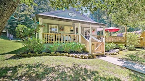 A small, single-story building with a porch, surrounded by a well-maintained garden and trees. - 'the Creek' Winfield Gem: 73 Acres of Privacy (Winfield)
