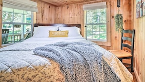 A wooden-paneled bedroom with a bed, a chair, and a window. - 'the Creek' Winfield Gem: 73 Acres of Privacy (Winfield)