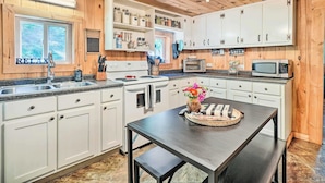 A kitchen with white cabinets, a black countertop, and a wooden ceiling. - 'the Creek' Winfield Gem: 73 Acres of Privacy (Winfield)
