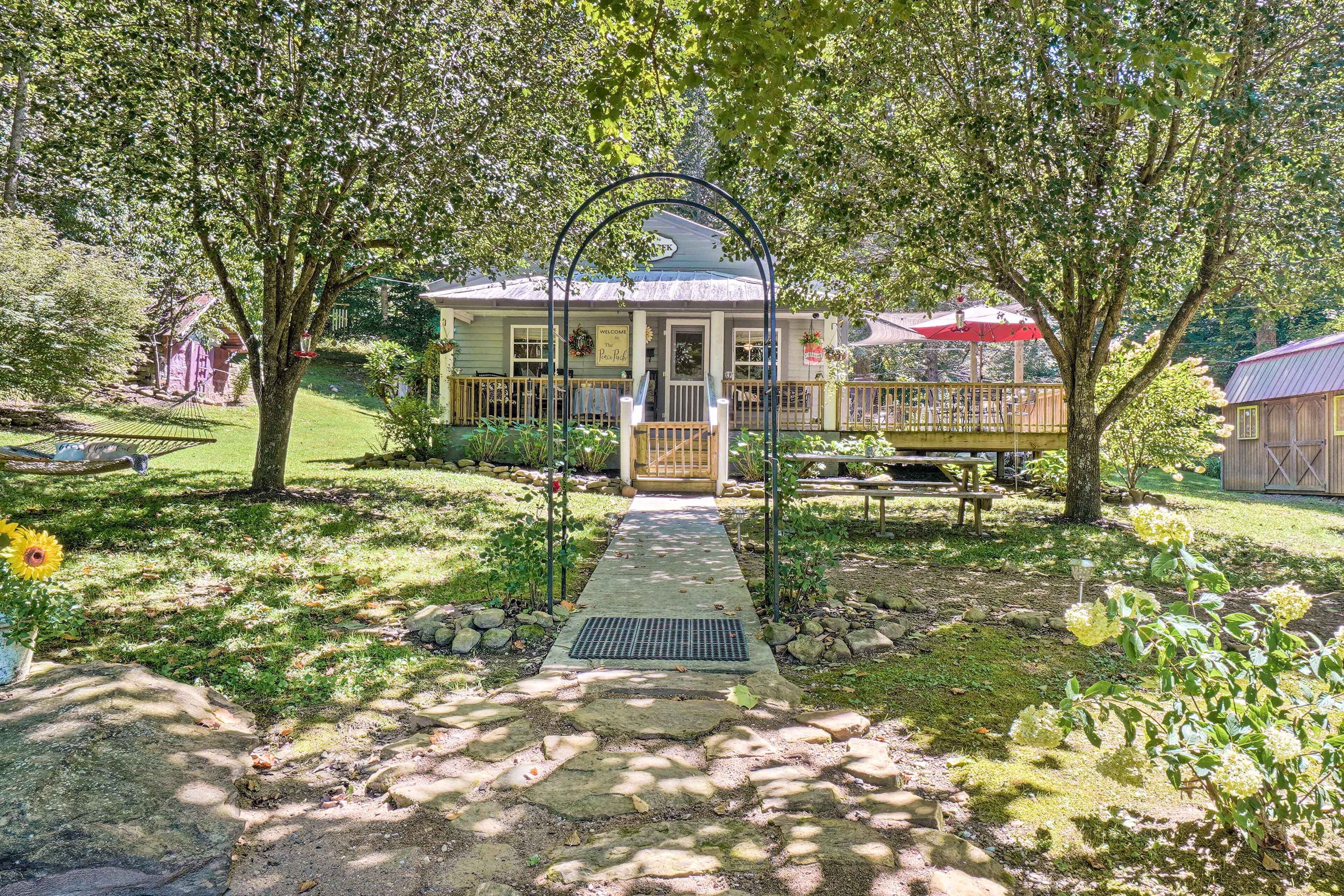 A house with a porch, a pathway leading to the entrance, and a small garden area.