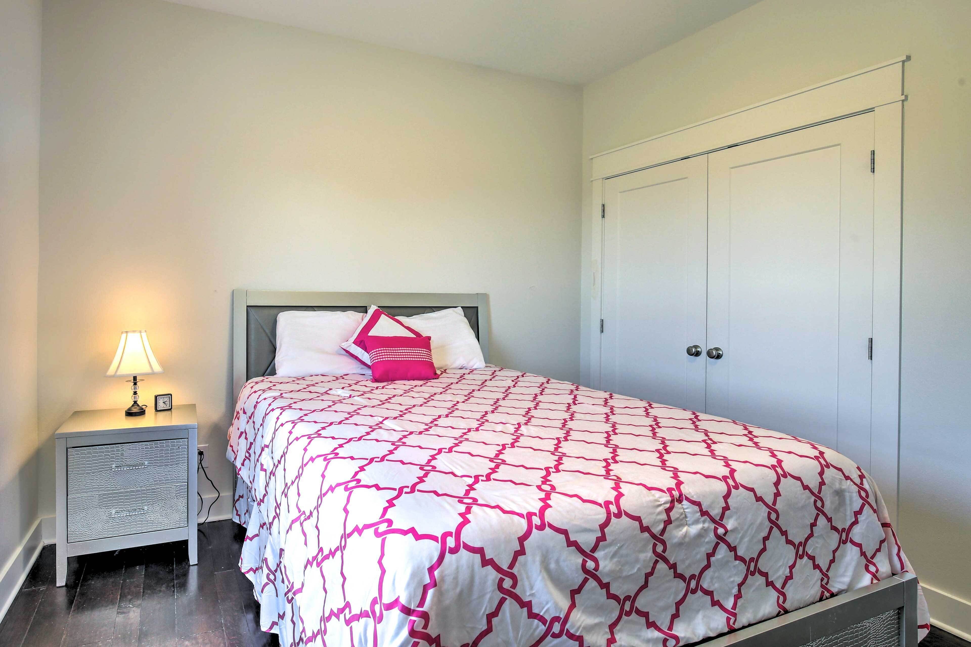 A bedroom with a bed, a nightstand with a lamp, and a wardrobe.