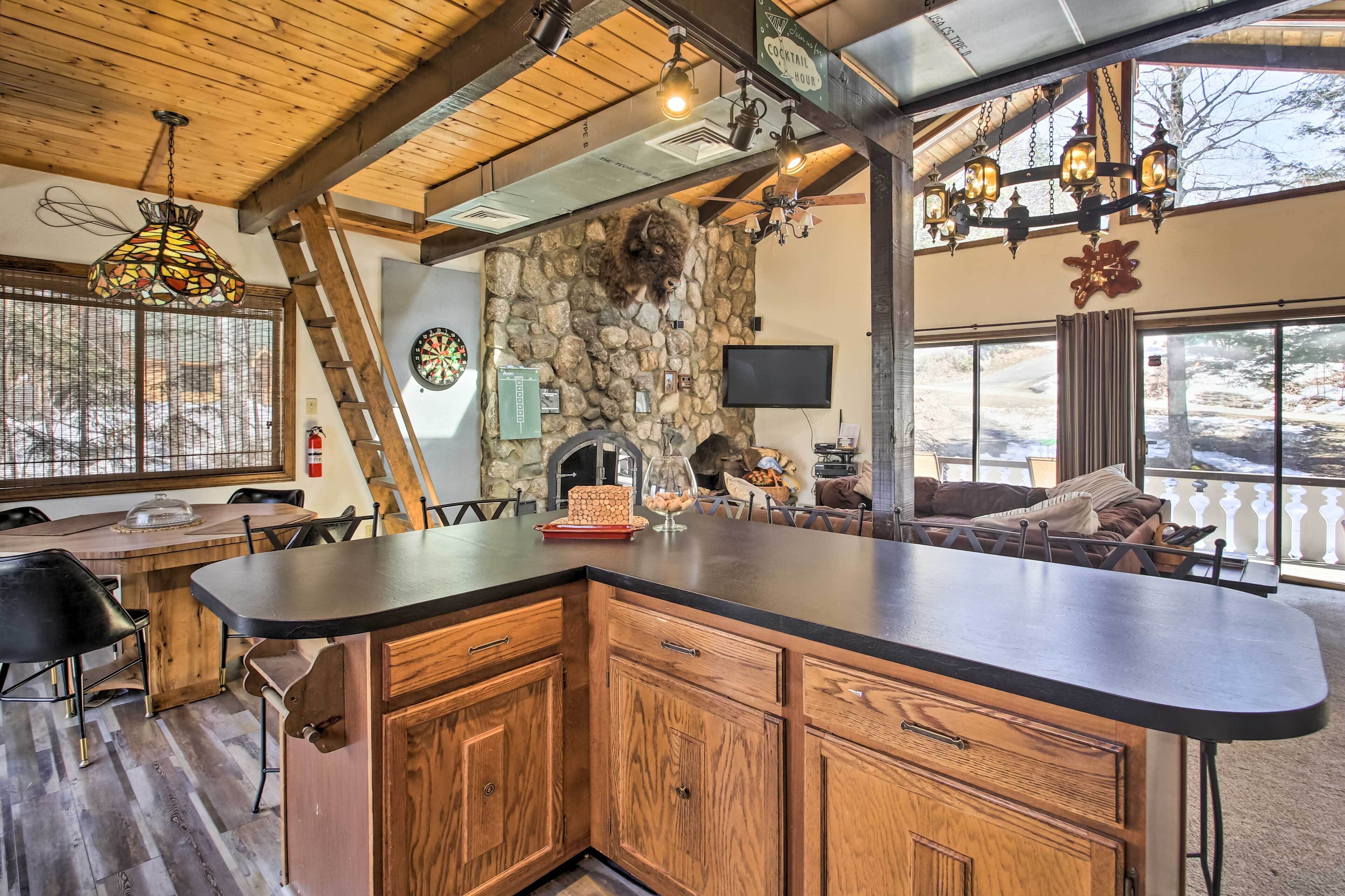 A spacious kitchen with a large island, wooden cabinets, and a stone accent wall.