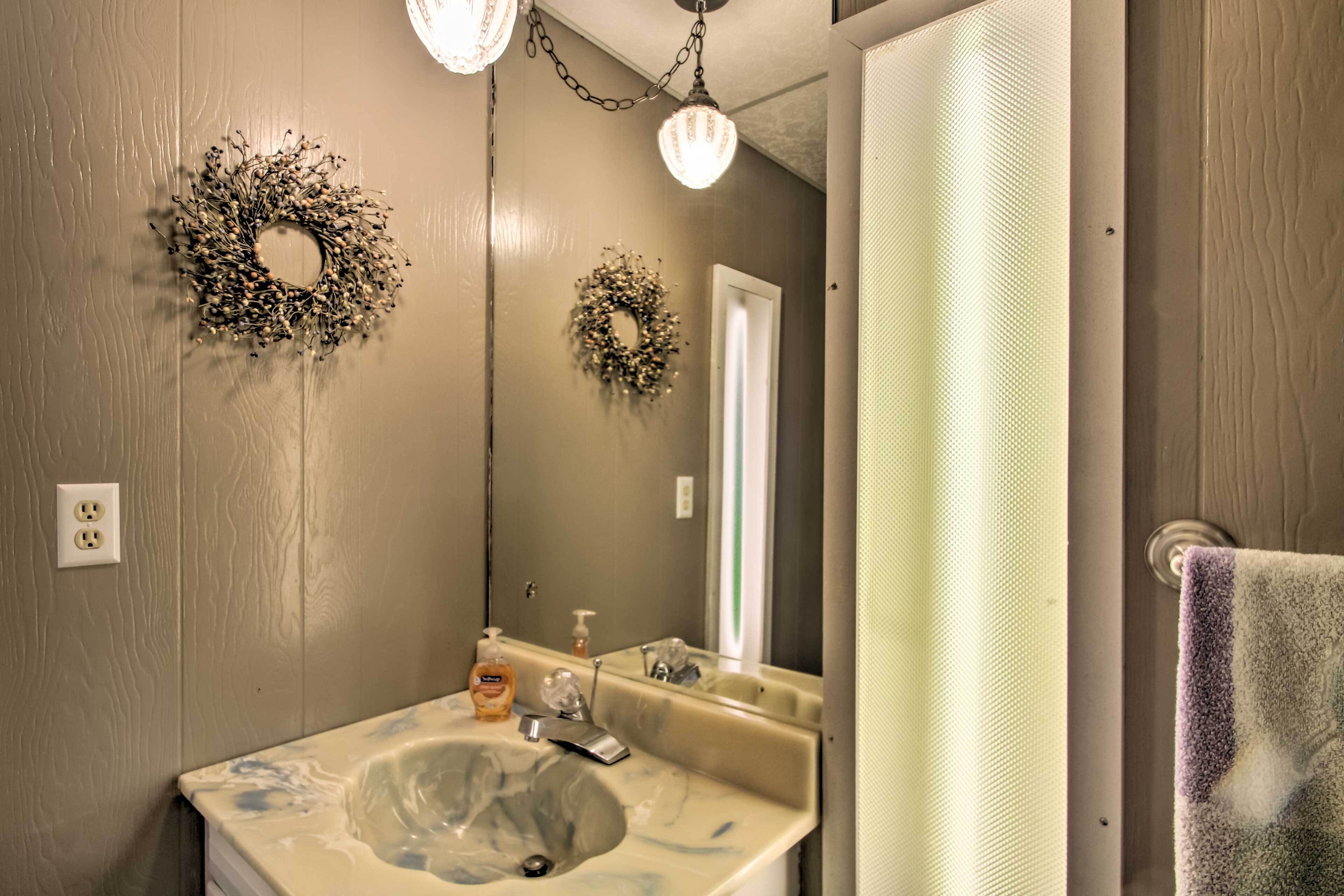 A bathroom with a sink, mirror, and two wall-mounted light fixtures.