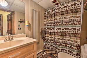 A bathroom with a wooden vanity, a sink, and a toilet.