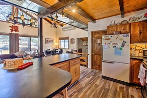 A spacious kitchen with wooden cabinets, a large island, and a refrigerator.