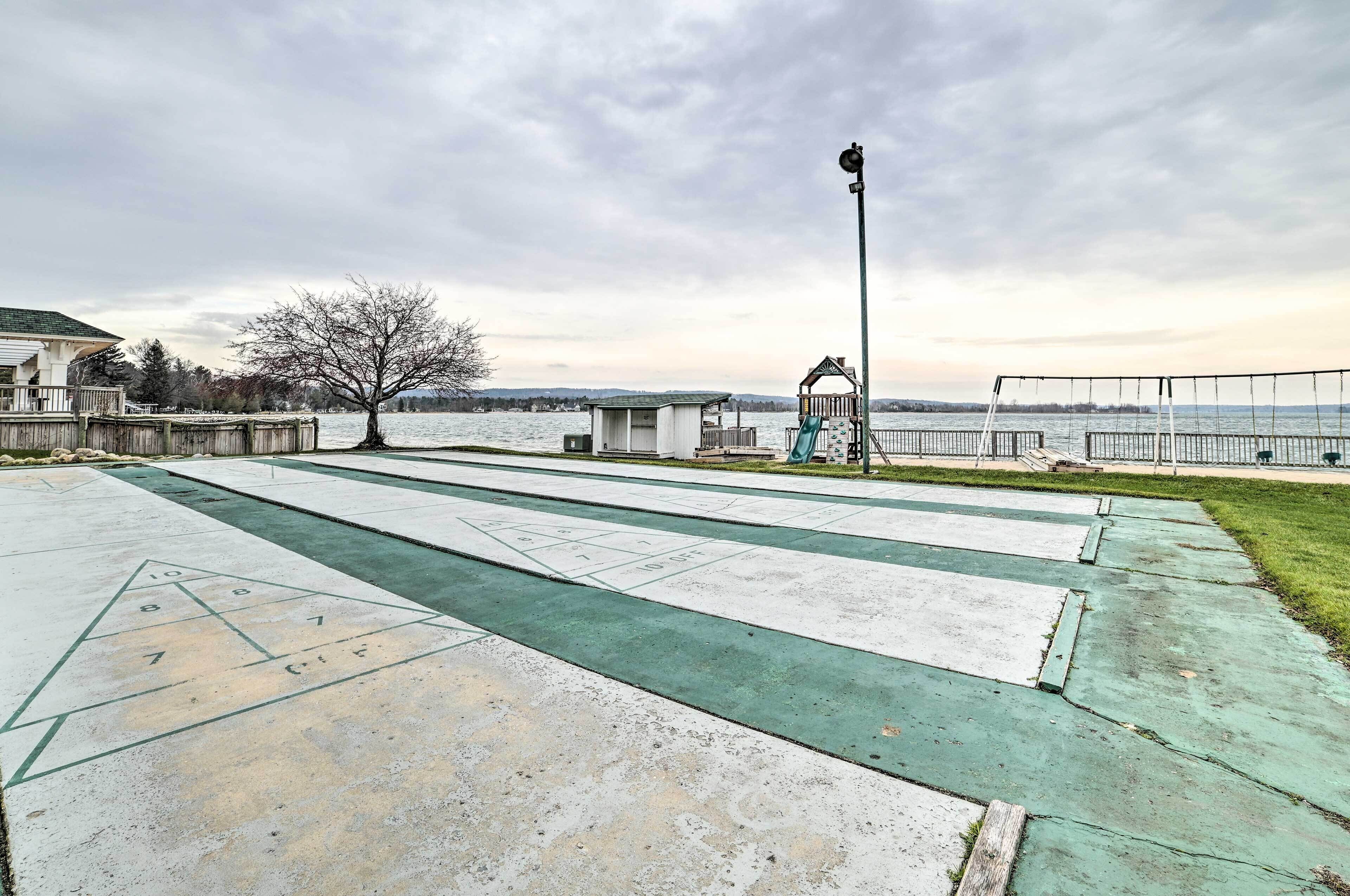 Una cancha de shuffleboard con vistas a un lago y un parque infantil.