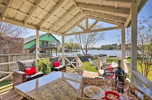A covered outdoor area with a table, chairs, and a view of a lake. - Lakeside Hideaway Cabin - Rest & Recharge (Willis)