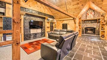 Cozy up by the fireplace with a comfortable leather sofa and enjoy the vaulted wooden ceiling.