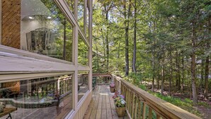 A wooden deck with a glass balustrade overlooking a forested area. - Pocono Lake Paradise w/ Private Beach & Dock! (Pocono Lake)