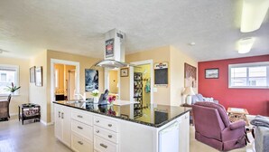 A spacious kitchen with white cabinets, a granite countertop, and a built-in oven.