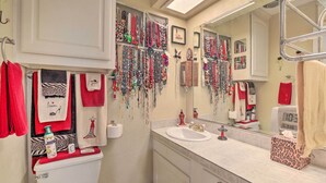 A bathroom with a white sink, a mirror, and various toiletries. - Home 1 Mi to University of Texas: Relax Fireside! (Richardson)