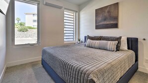 Une chambre à coucher avec un lit, une fenêtre, un tableau et un ventilateur de plafond.