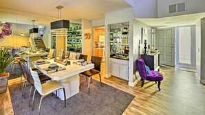 Un comedor amplio con una isla grande, una cocina con armarios blancos y una silla morada.