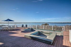 A wooden deck with a pool, white chairs, and a blue umbrella. - Waterfront Home w/ Large Deck + Private Pool! (Westhampton Beach)
