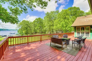 A wooden deck with outdoor furniture, a view of trees and a body of water. - Large Lakefront Home Pool, Hot Tub & Boat Dock (Grove)