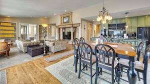 A spacious living room with a fireplace, dining area, and kitchen with green cabinets. - Hot Tub & Snake River Views at Twin Falls Home (Twin Falls)