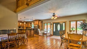 A spacious kitchen with wooden cabinets, a dining area with a round table and chairs, and a ceiling fan. - Tryon House w/ Hot Tub - Near Equestrian Centers! (Tryon)