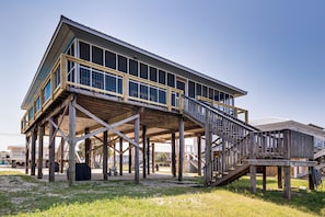 Un bâtiment doté d’une terrasse en bois, d’un escalier et d’une grande section vitrée.